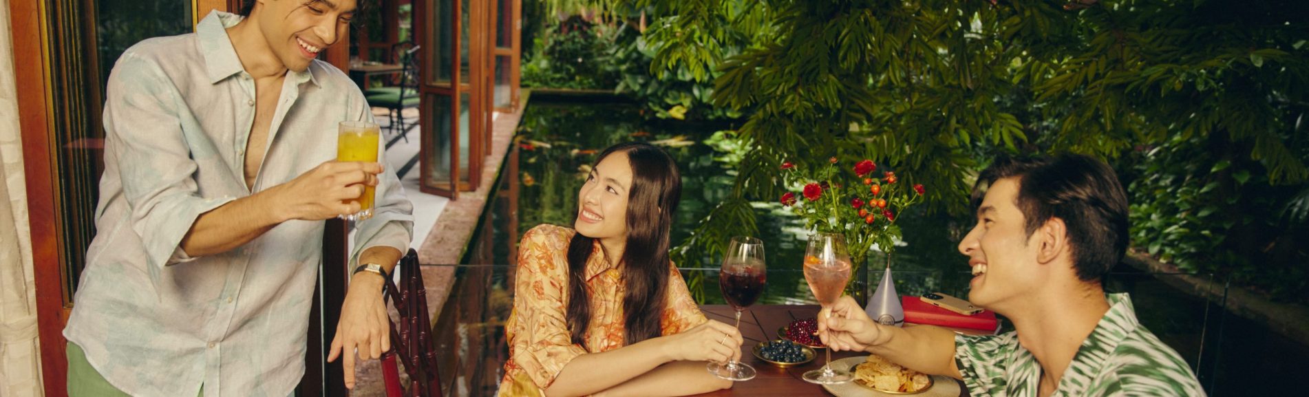Guests enjoying drinks beside the garden pond at Jim Thompson restaurant